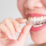 smiling-woman-holding-invisalign-invisible-braces_43937-94